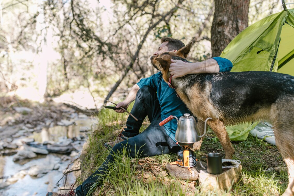 Portable camping water filter straw resting beside a stream for outdoor backpacking and camping trips